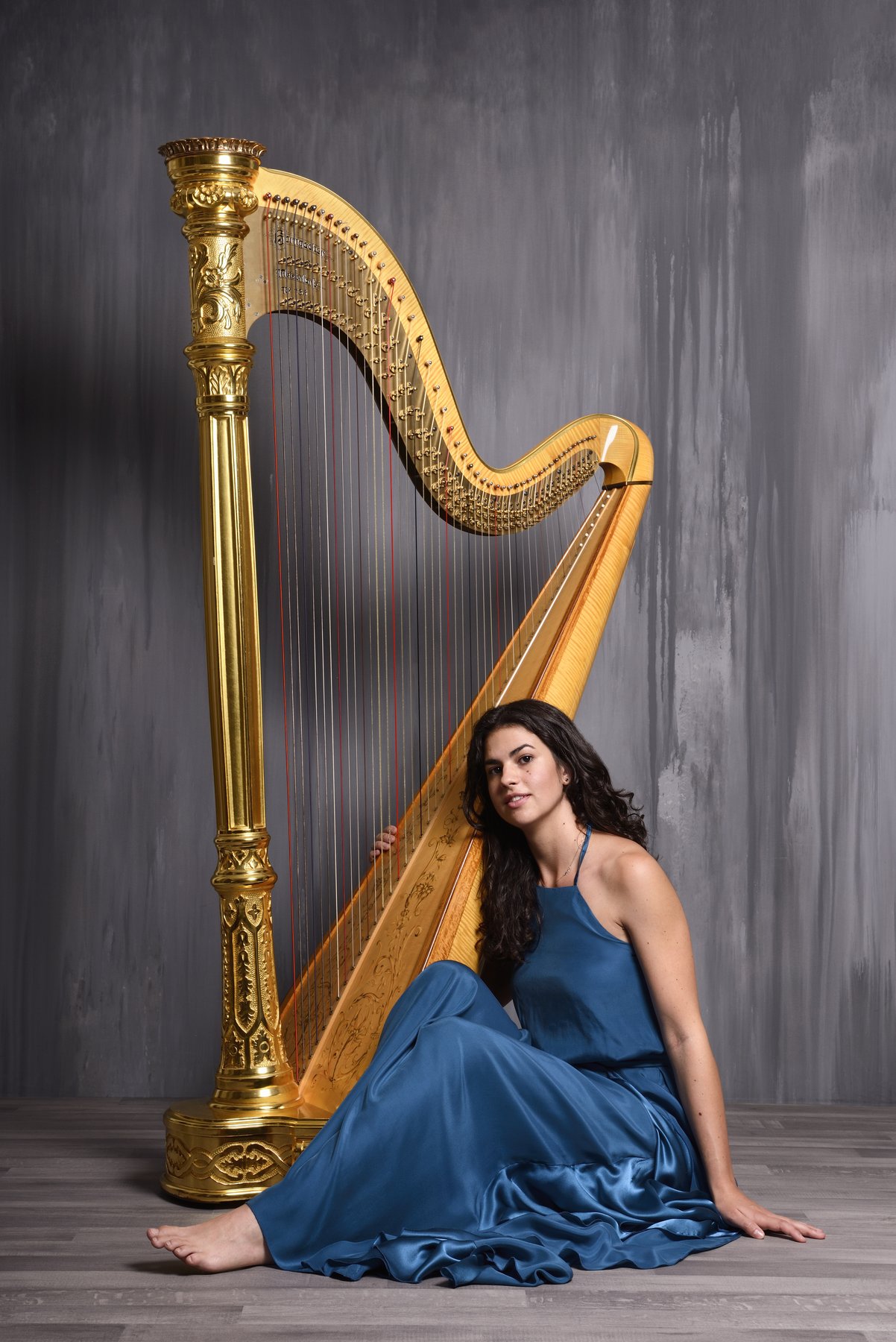 Irene Pauletto with her harp in blue stage light