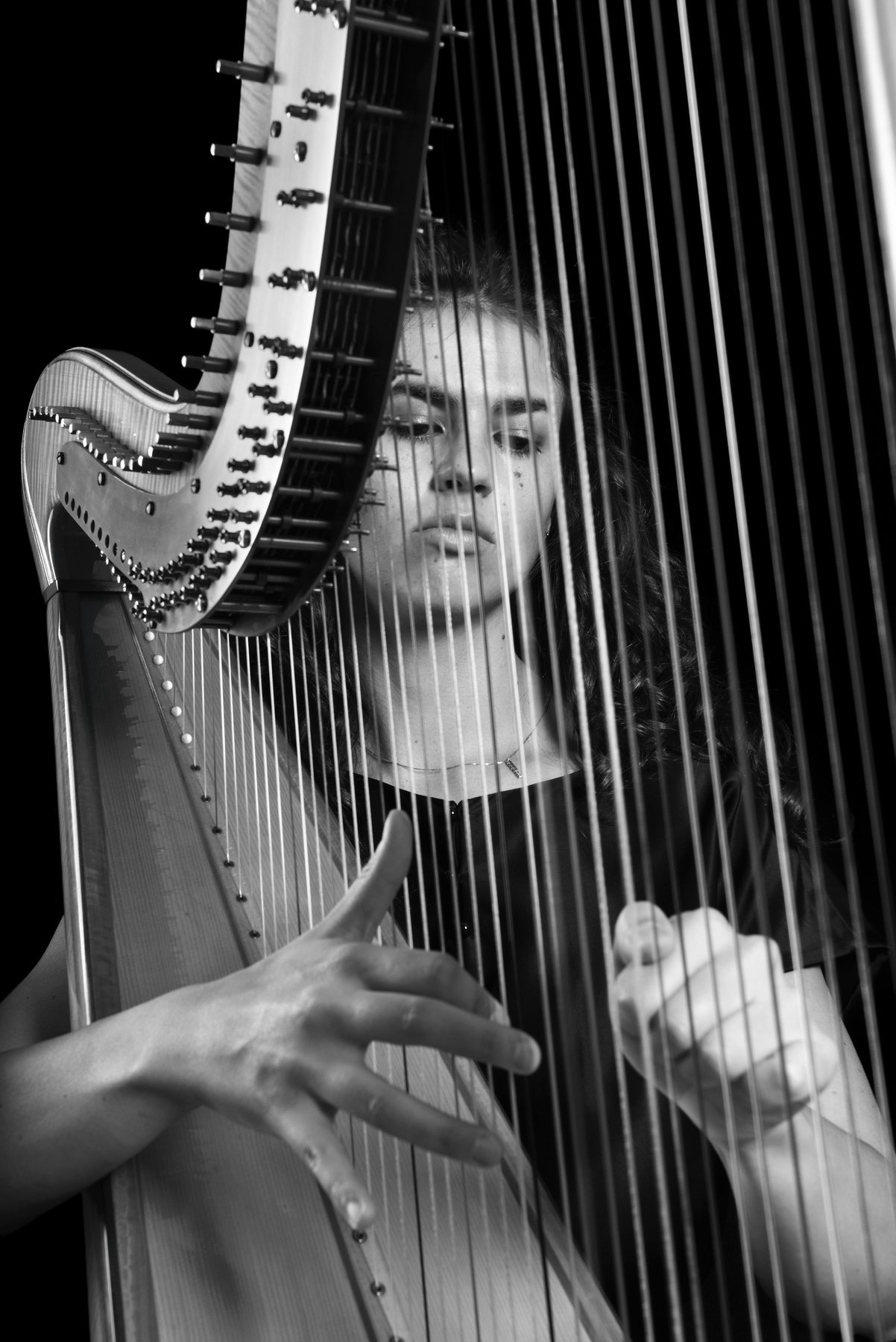 Irene Pauletto performing on the harp in black and white